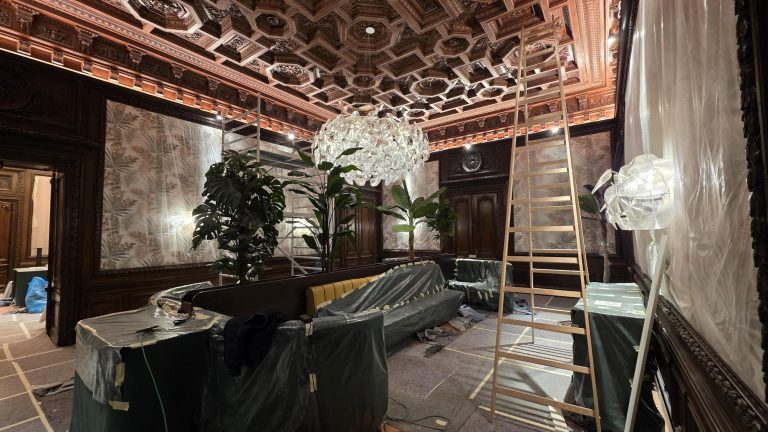 Salon eines Wiener Hotels mit historischer Kassettendecke, Lichtvoute und großen Pendelleuchten während der Inbetriebnahme